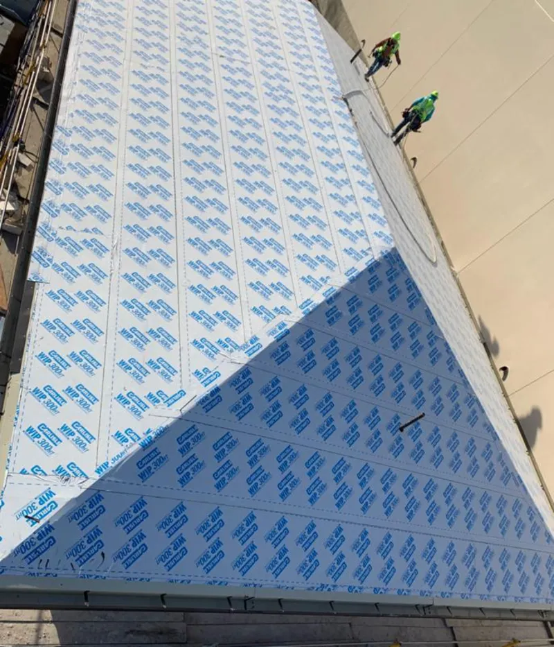 Professional roofers installing underlayment on a metal roof in Laurel Bay